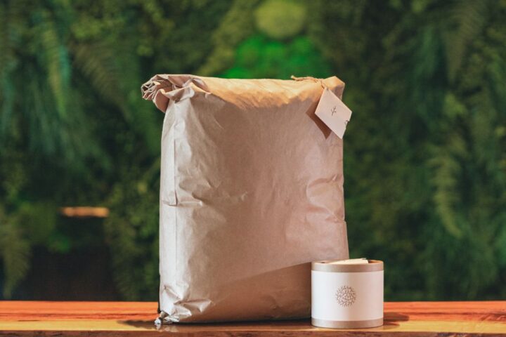 two human composting soil packages a large paper bag and a small container