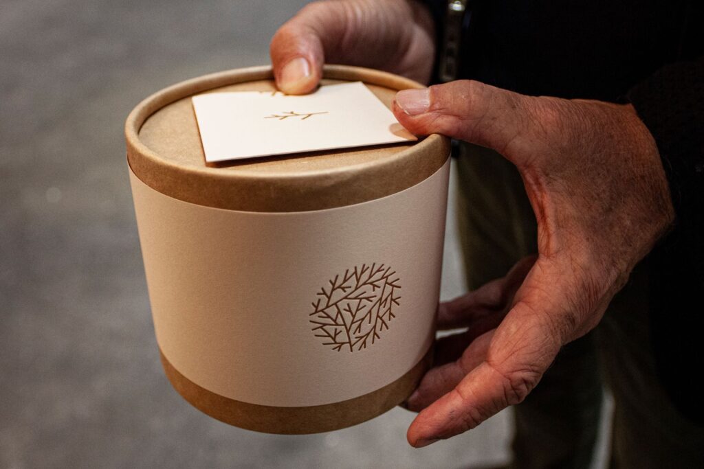 person carrying a small container of human composting soil