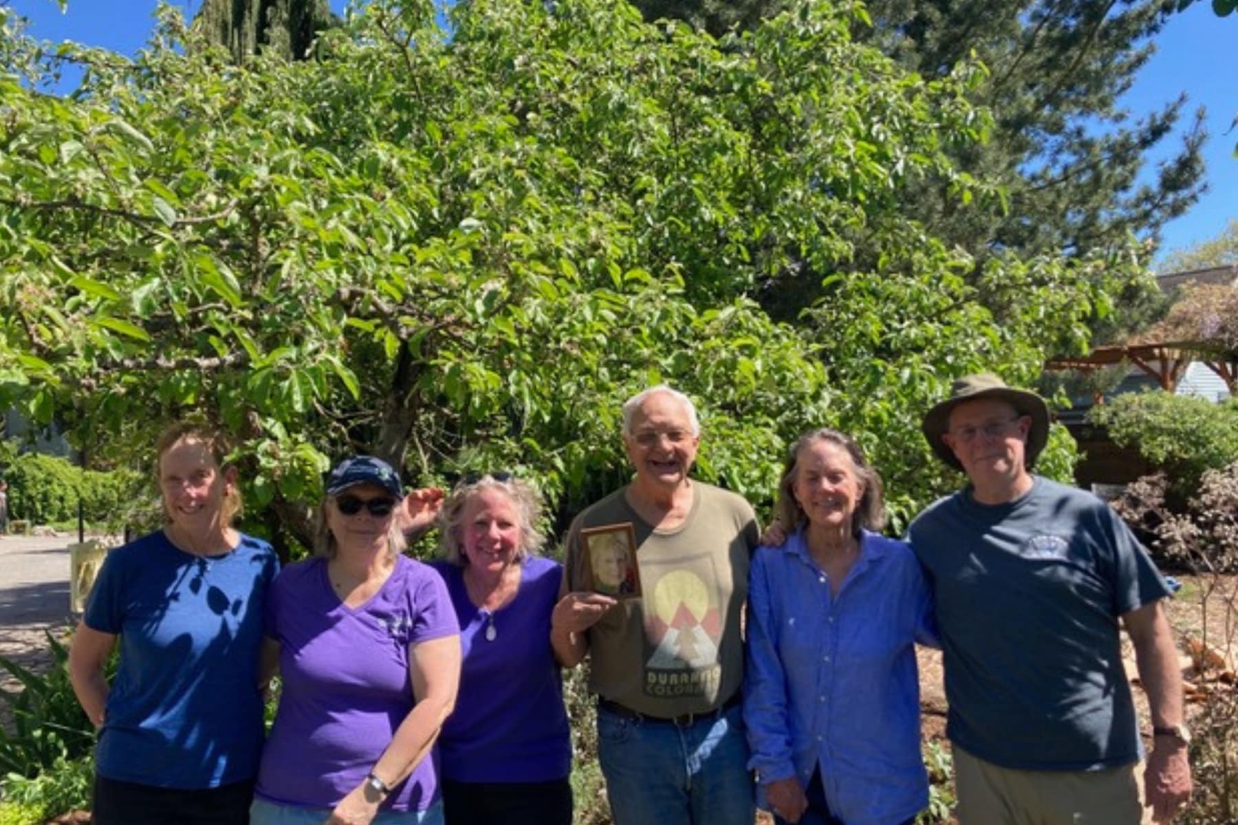 six people by an apple tree