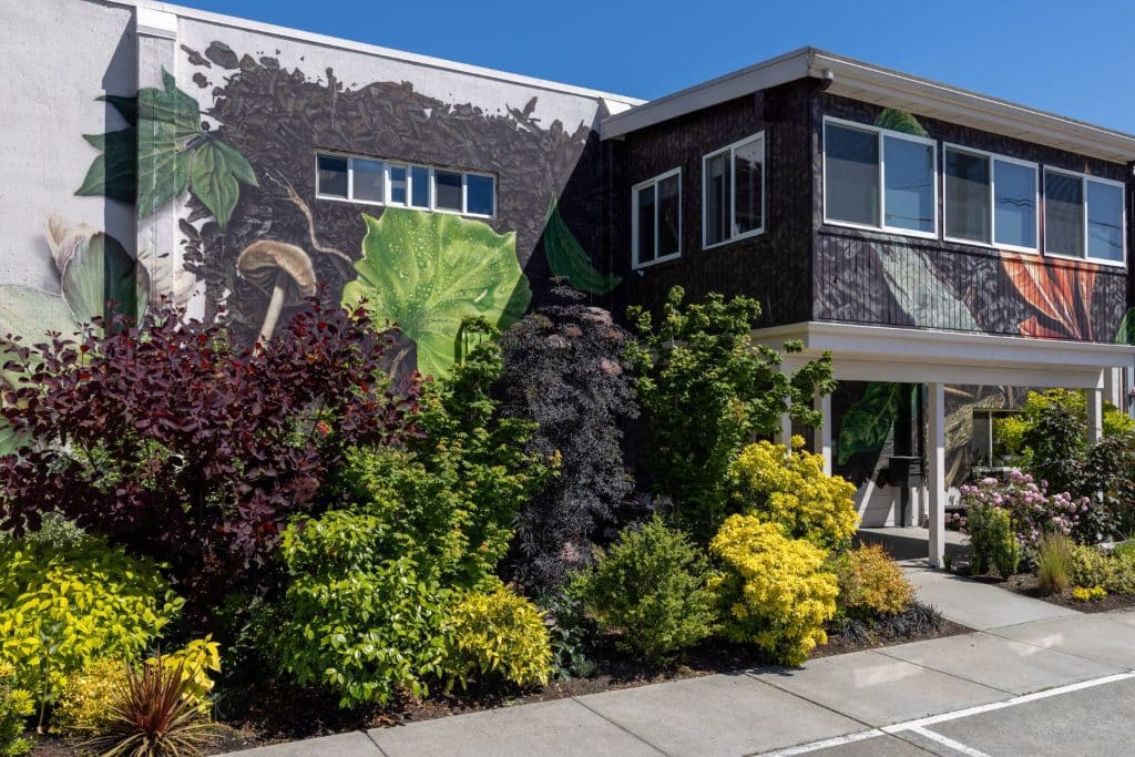 outside of funeral home with lush plants and mural on the building