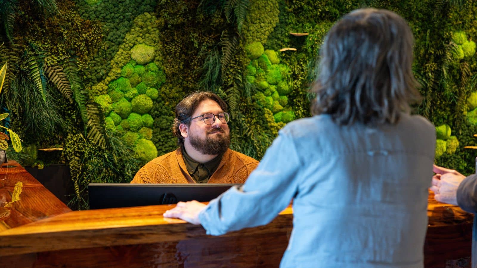 person smiling at a desk talking to a client