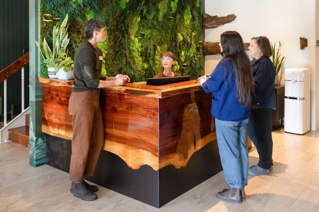 four people standing in lobby of funeral home around a desk