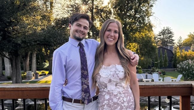 two people dressed up standing next to each other outside